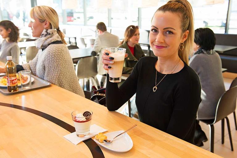 Woman in the restaurant enjoys a latte macchiato