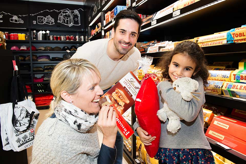 Vater, Mutter und Tochter kaufen Schokoladen im Shop